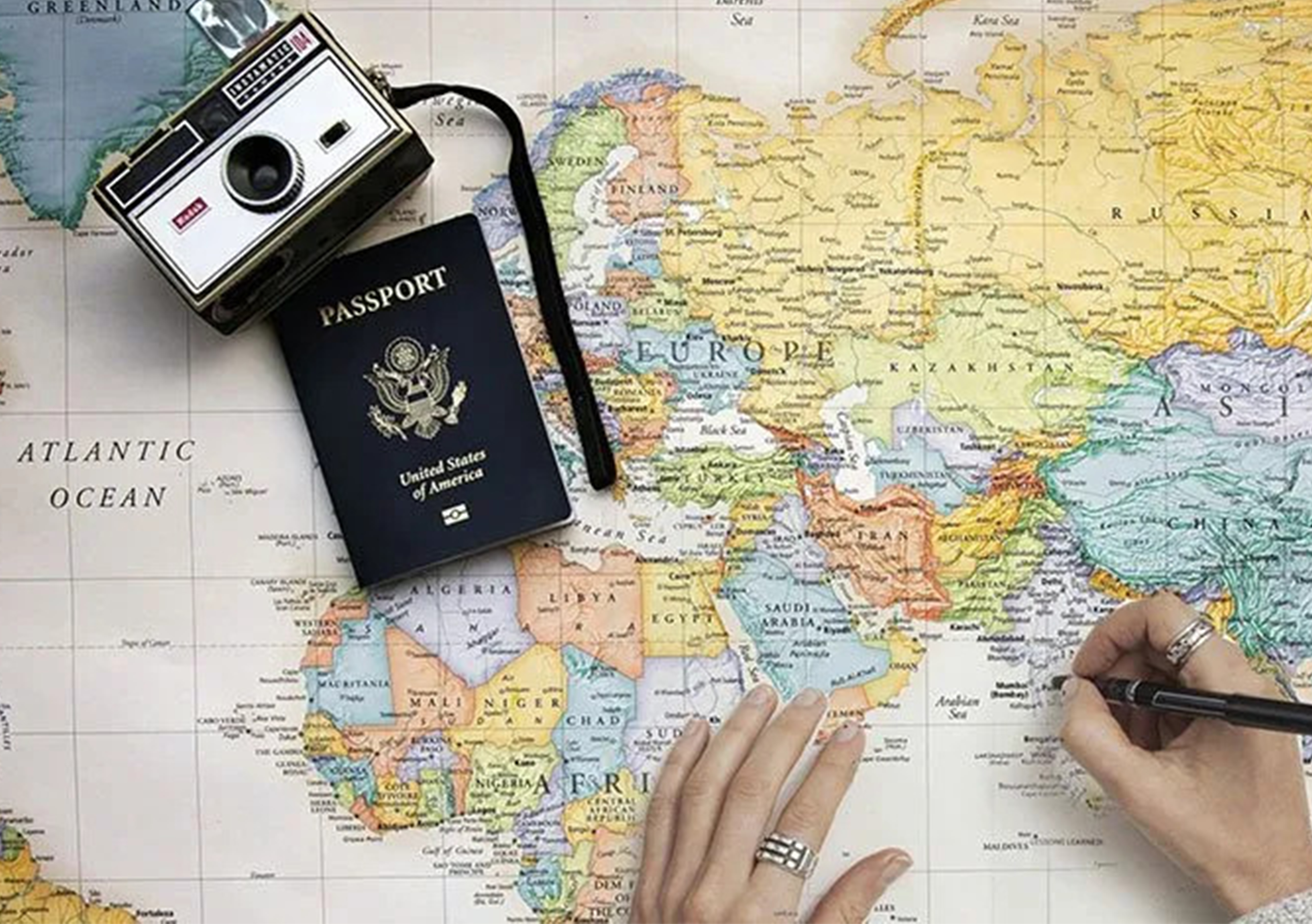 camera, passport, and map with someone writing